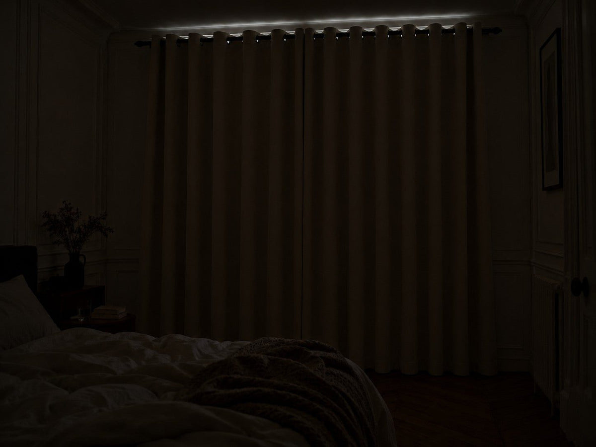 Chambre dans le noir complet en plein jour, rideaux occultants blanc cassé fermés