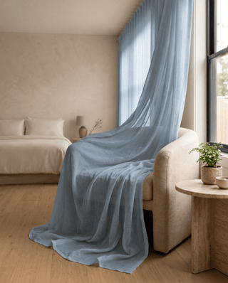 Voilage bleu ciel léger drapé sur un fauteuil